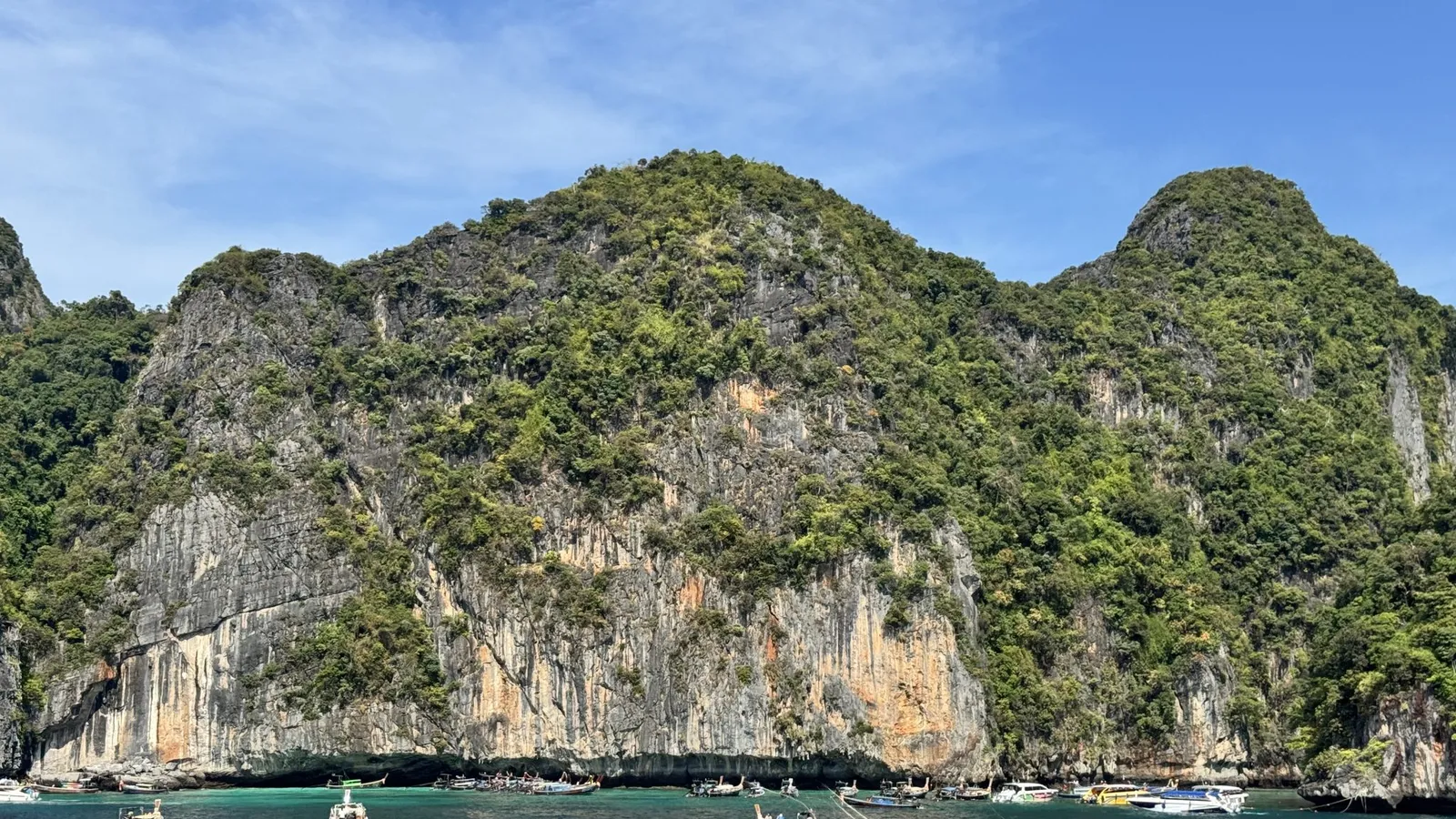 Limestone cliffs covered in green forest rising from the sea near Krabi